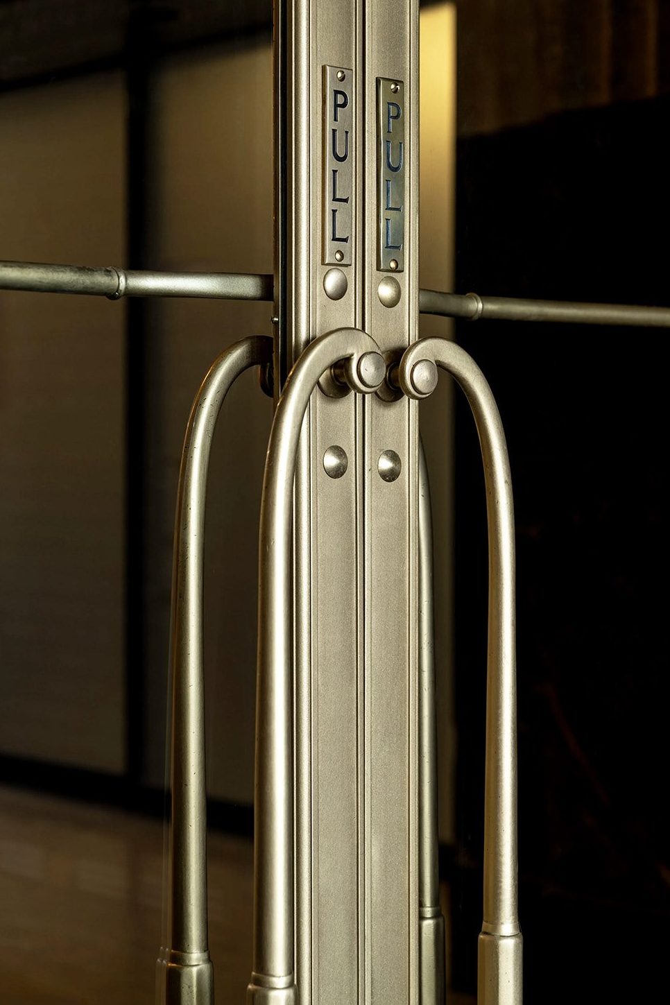 Exterior entrance bronze door handle and pull plate after restoration