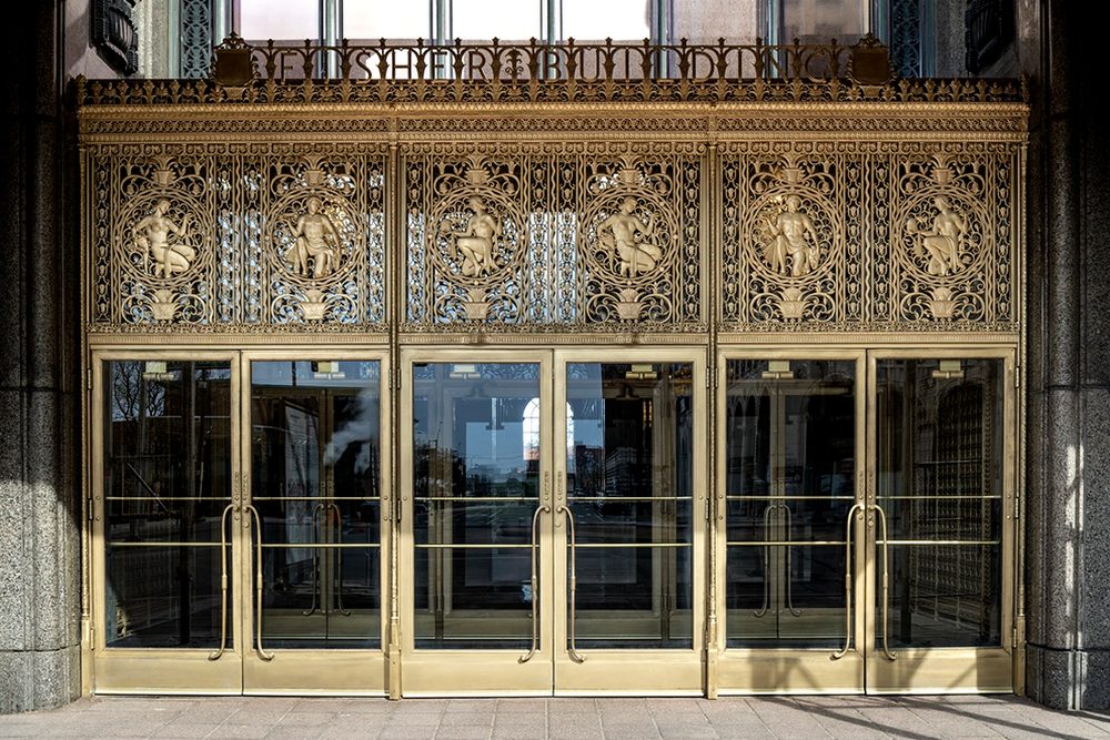 Fisher Building main entrance after restoration, with new bronze swing doors, refinished doors, header grille and eyebrow signage