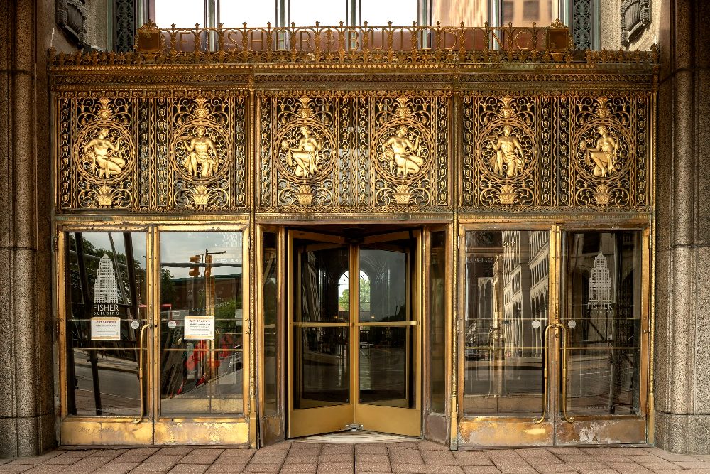 Fisher Building main entrance before restoration, with weathered bronze grille and doors
