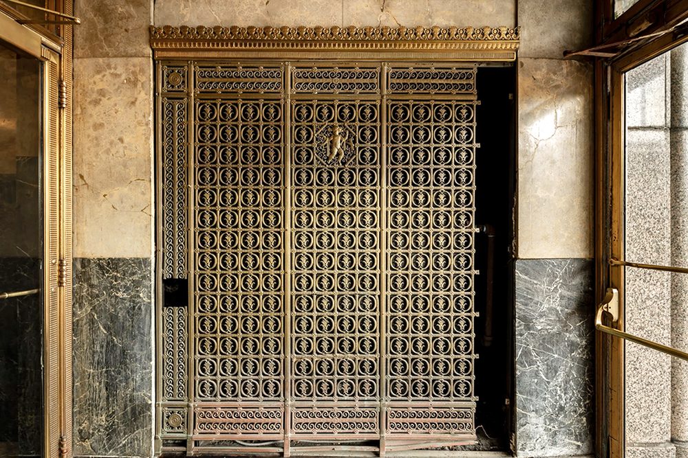 Vestibule bronze ornamental HVAC grille before restoration, tarnished